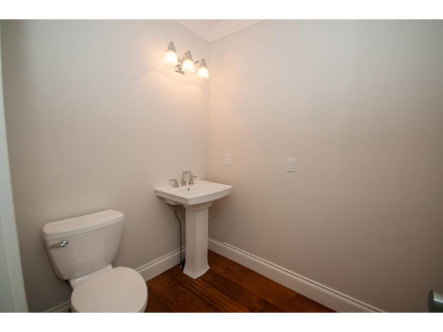 Bright bathroom with white sink, toilet, and hardwood floors. - 3476 Wellington Crescent, North Vancouver