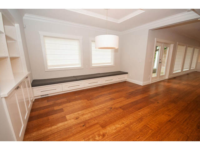 Bright living room with hardwood floors and built-in bench seating. - 3476 Wellington Crescent, North Vancouver