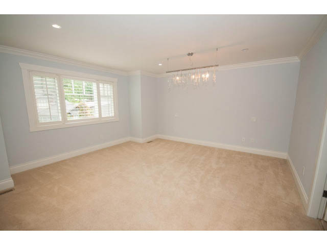 Bright den with beige carpet, white walls, and a chandelier. - 3476 Wellington Crescent, North Vancouver