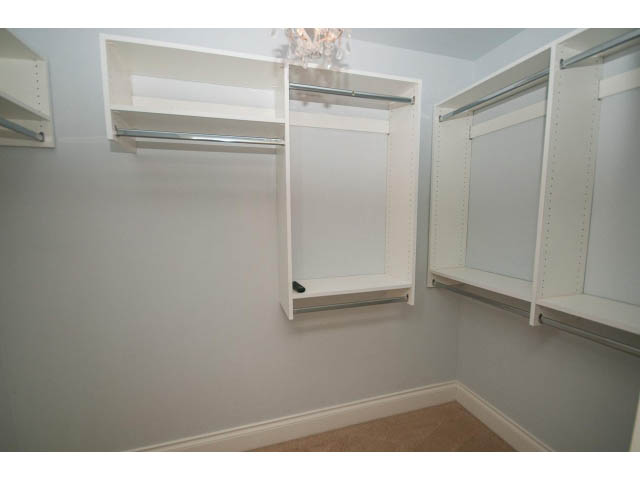 Walk-in closet with built-in shelves and a chandelier. - 3476 Wellington Crescent, North Vancouver
