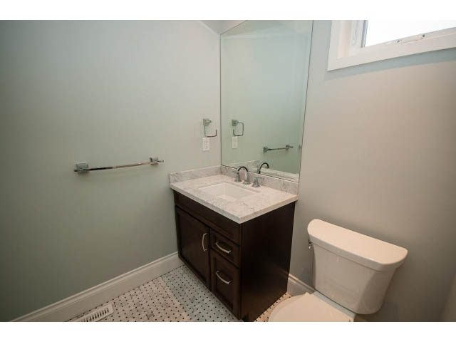Bathroom with white countertop, dark cabinets, and patterned floor tiles. - 3476 Wellington Crescent, North Vancouver