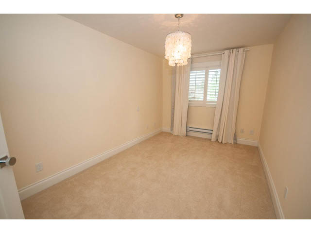 Bright den with beige carpet and chandelier, window with white curtains. - 3476 Wellington Crescent, North Vancouver