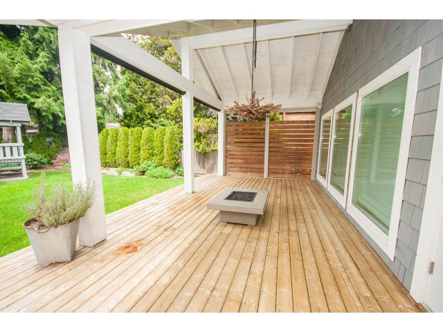 Spacious deck with wooden flooring and privacy wall, perfect for outdoor relaxation. - 3476 Wellington Crescent, North Vancouver