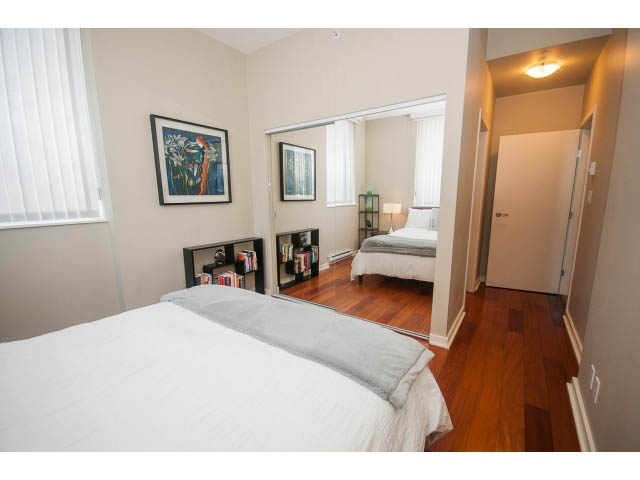 Bright bedroom with hardwood floors and a large mirror, showcasing a cozy and modern design. - 3206 - 455 Beach Crescent, Vancouver Downtown