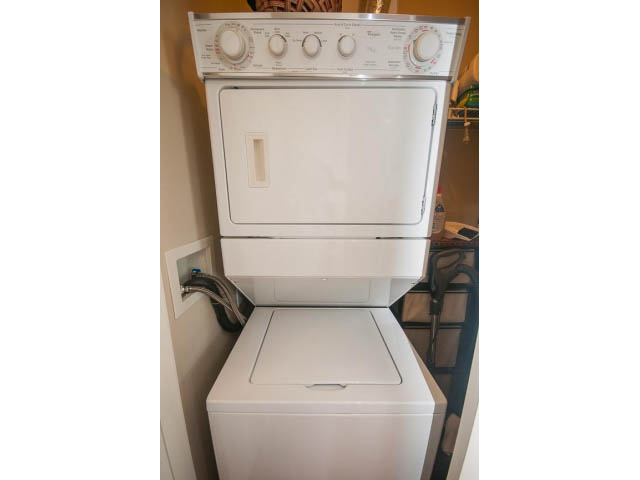 Bright laundry room with stacked washer and dryer, white cabinets. - 3206 - 455 Beach Crescent, Vancouver Downtown