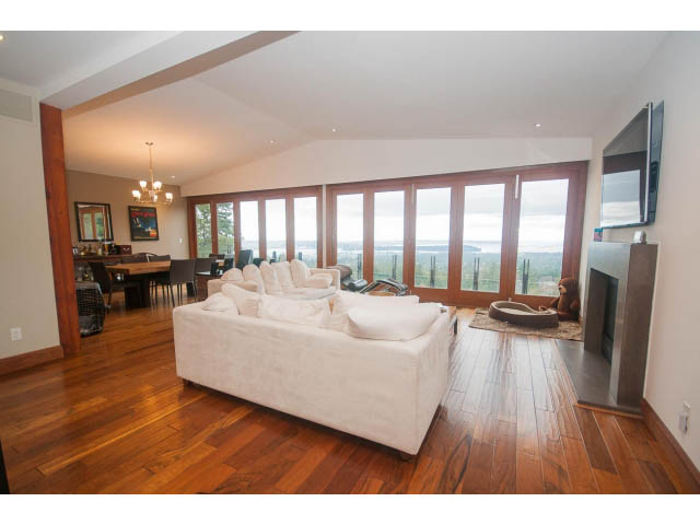 Spacious living room with hardwood floors, city view, and modern furnishings. - Upper - 4407 Prospect Rd, North Vancouver