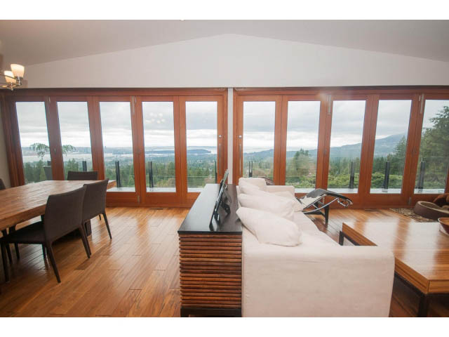 Bright living room with hardwood floors, city view, and large windows. - Upper - 4407 Prospect Rd, North Vancouver