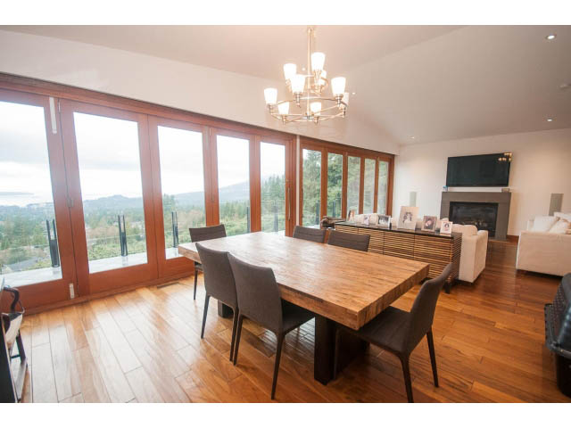 Spacious dining area with hardwood floors, city view, and modern chandelier. - Upper - 4407 Prospect Rd, North Vancouver