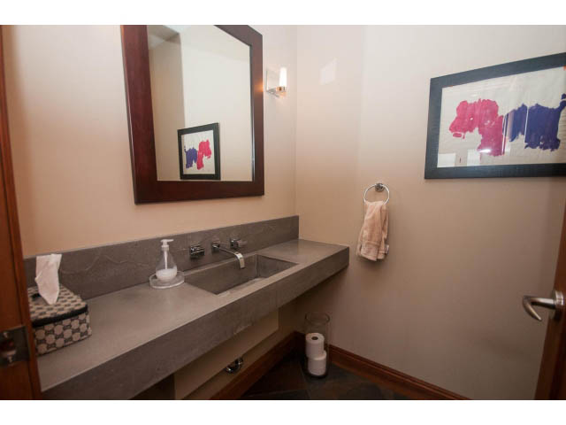 Modern bathroom with sleek concrete countertops and framed artwork. - Upper - 4407 Prospect Rd, North Vancouver