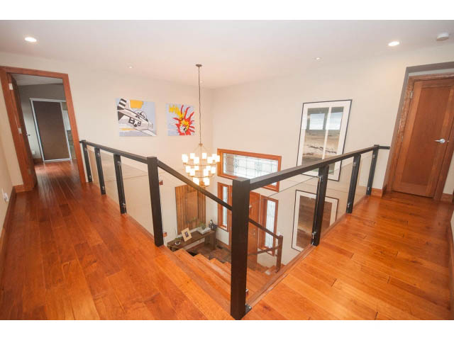 Bright living room with hardwood floors and modern glass railings. - Upper - 4407 Prospect Rd, North Vancouver