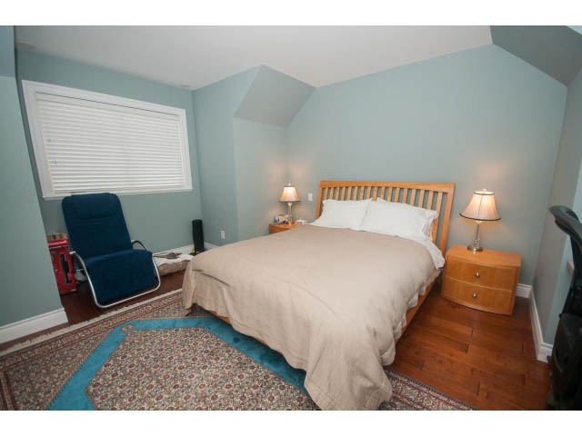 Furnished bedroom with hardwood floors and a patterned rug. - Upper - 4407 Prospect Rd, North Vancouver