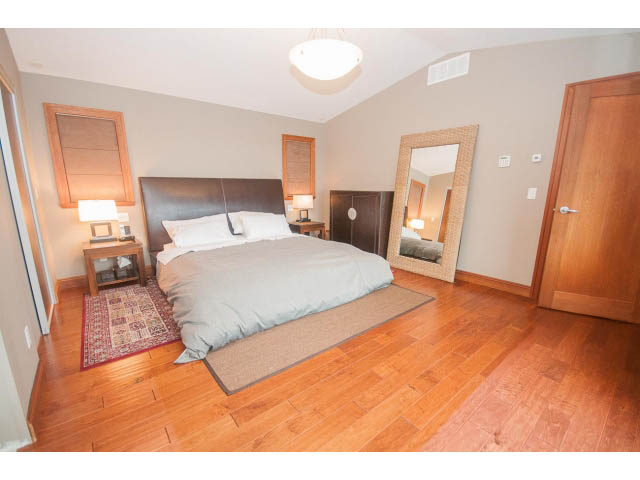 Furnished bedroom with hardwood floors and a large mirror. - Upper - 4407 Prospect Rd, North Vancouver
