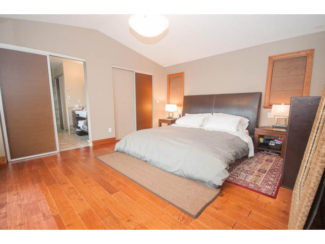 Furnished bedroom with hardwood floors and sliding closet doors. - Upper - 4407 Prospect Rd, North Vancouver