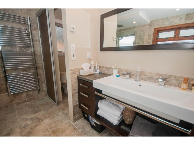 Furnished bathroom with modern sink, large mirror, and tiled floor. - Upper - 4407 Prospect Rd, North Vancouver