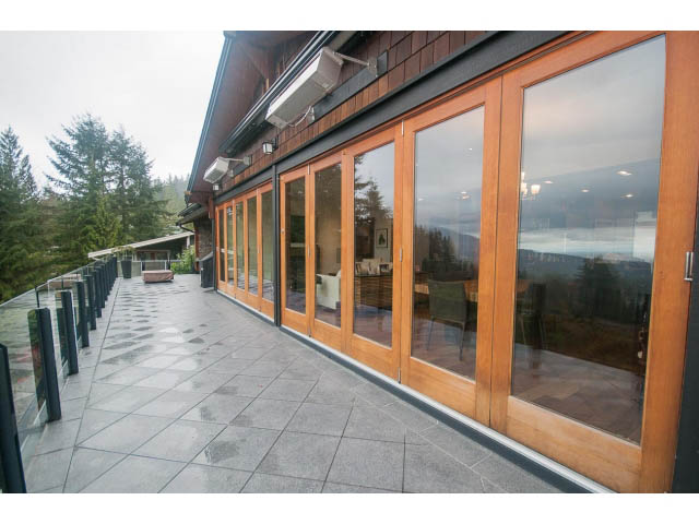 Bright living room with large windows and wooden floors, showcasing a serene outdoor view. - Upper - 4407 Prospect Rd, North Vancouver