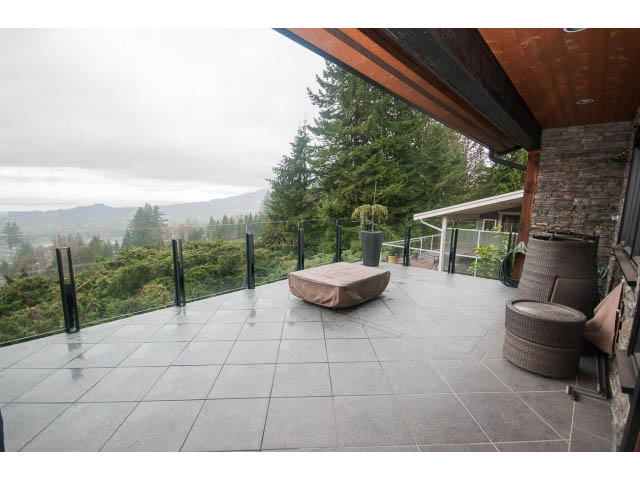 Furnished living room with large windows, city view, and cozy seating. - Upper - 4407 Prospect Rd, North Vancouver