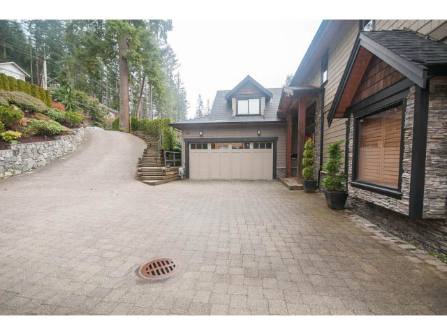 Furnished living room with stone fireplace and large windows. - Upper - 4407 Prospect Rd, North Vancouver