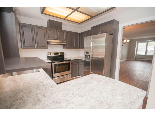 Bright kitchen with granite countertops, stainless steel appliances, and hardwood floors. - Upper - 113 W Kings Rd, North Vancouver