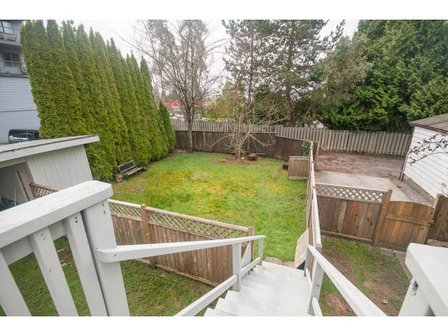 Stairway leading to a grassy backyard with wooden fencing and trees. - Upper - 113 W Kings Rd, North Vancouver