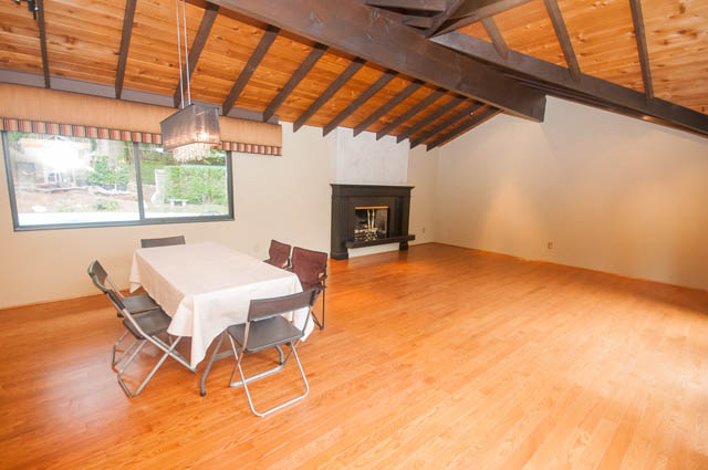 Spacious living room with hardwood floors, fireplace, and large windows. - 4645 Caulfeild Drive, West Vancouver