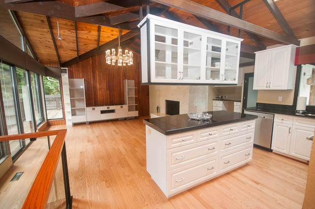 Bright kitchen with white cabinets, hardwood floors, and a city view. - 4645 Caulfeild Drive, West Vancouver