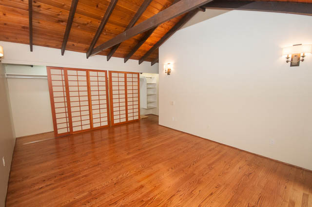 Bright open-concept living area with hardwood floors and wooden ceiling beams. - 4645 Caulfeild Drive, West Vancouver