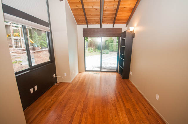 Bright living room with hardwood floors and sliding glass doors leading to a garden. - 4645 Caulfeild Drive, West Vancouver