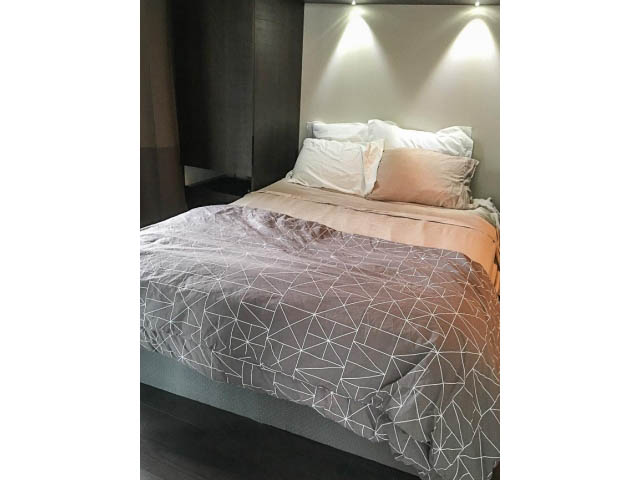 Furnished 1-bedroom with geometric-patterned bedding and modern lighting. - 1802 - 1351 Continental St., Vancouver Downtown