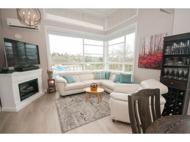 Spacious living room with large windows, hardwood floors, and a cozy fireplace. - 624 - 723 W 3rd St, North Vancouver