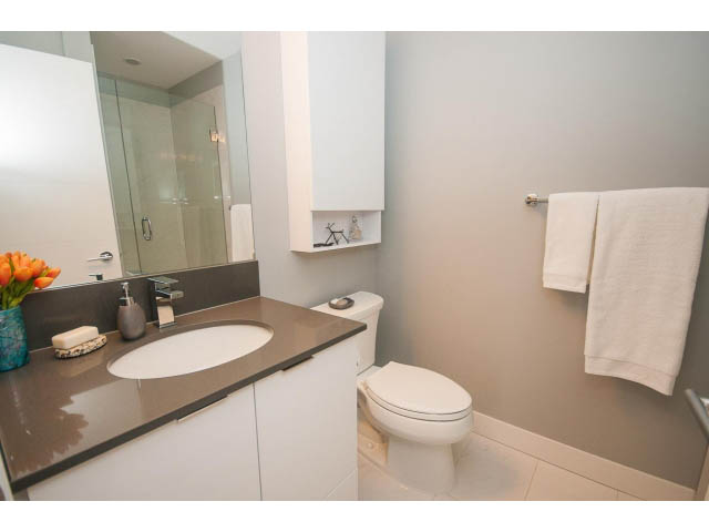 Bright bathroom with modern sink, white toilet, and neatly folded towels. - 624 - 723 W 3rd St, North Vancouver