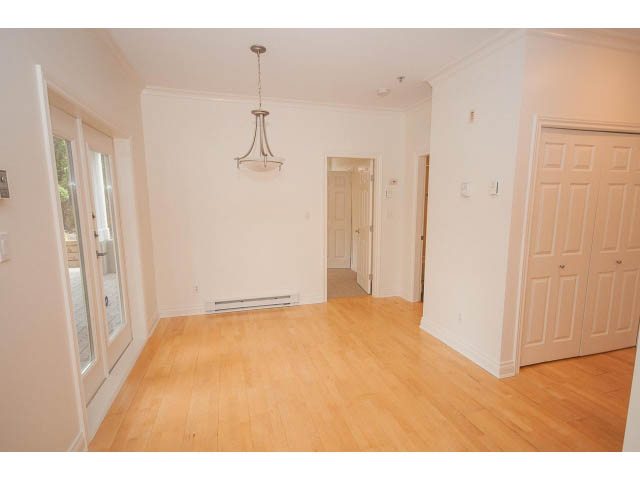 Bright kitchen with hardwood floors and white cabinetry. - 104 - 128 West 21st St, North Vancouver
