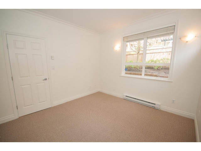 Bright bedroom with carpeted floor and large window view. - 104 - 128 West 21st St, North Vancouver