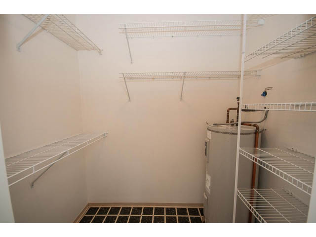 Storage closet with white wire shelving and a water heater in the corner. - 104 - 128 West 21st St, North Vancouver