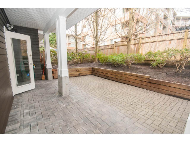 Furnished patio with wooden planters and brick flooring. - 104 - 128 West 21st St, North Vancouver