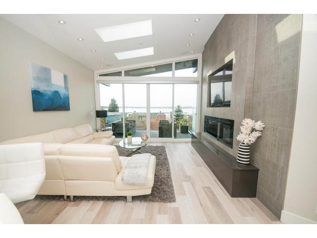 Spacious living room with hardwood floors, city view, and modern furnishings. - 2309 Bellevue Ave, West Vancouver