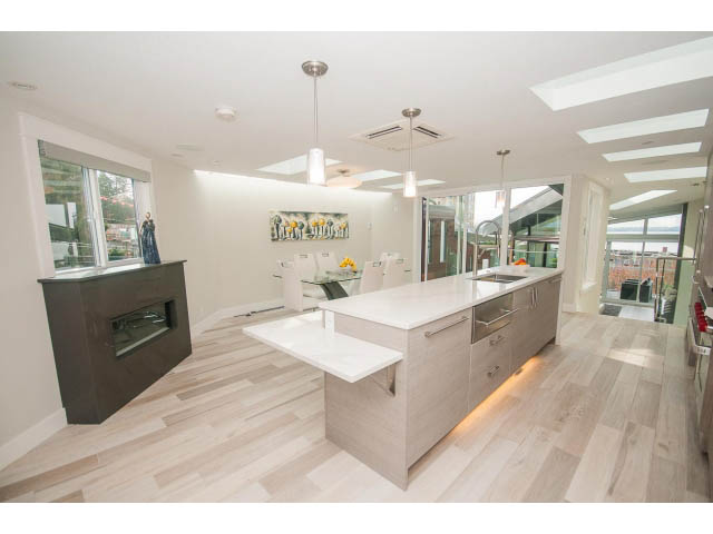 Bright kitchen with light wood floors, white countertops, and a city view. - 2309 Bellevue Ave, West Vancouver