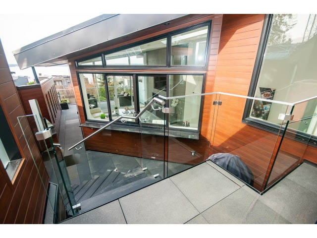 Bright living room with glass railings and wooden accents, modern design. - 2309 Bellevue Ave, West Vancouver