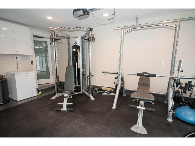 Fitness room with weightlifting equipment and rubber flooring. - 2309 Bellevue Ave, West Vancouver