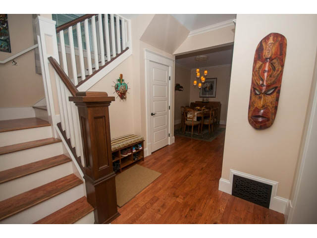 Furnished entryway with hardwood floors, staircase, and decorative wall art. - 266 W 6th St, North Vancouver