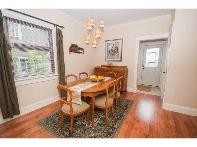Furnished dining area with hardwood floors, wooden chairs, and a chandelier. - 266 W 6th St, North Vancouver