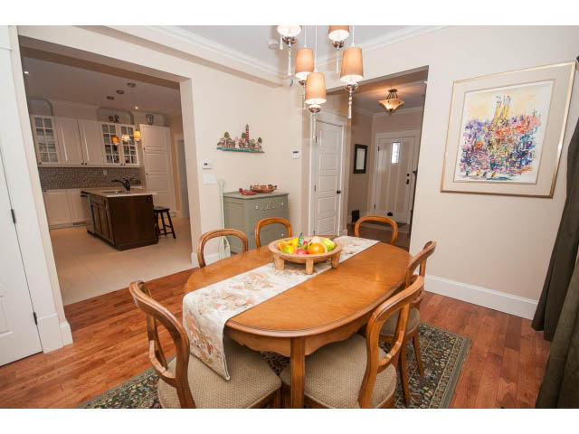 Furnished dining area with hardwood floors, chandelier, and artwork on the wall. - 266 W 6th St, North Vancouver