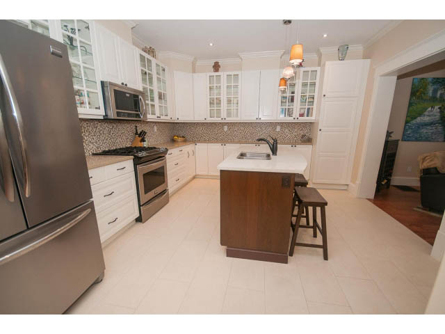 Bright kitchen with granite countertops, stainless steel appliances, and hardwood floors. - 266 W 6th St, North Vancouver