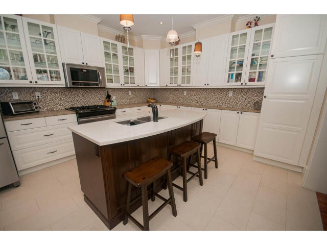 Bright kitchen with white cabinetry, granite countertops, and hardwood floors. - 266 W 6th St, North Vancouver