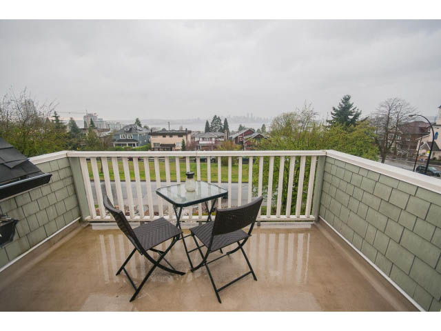 Furnished patio with folding chairs and glass table, city view in the background. - 266 W 6th St, North Vancouver