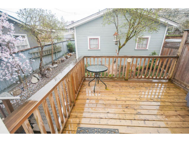 Furnished deck with wooden stairs, outdoor table, and cherry blossom trees. - 266 W 6th St, North Vancouver