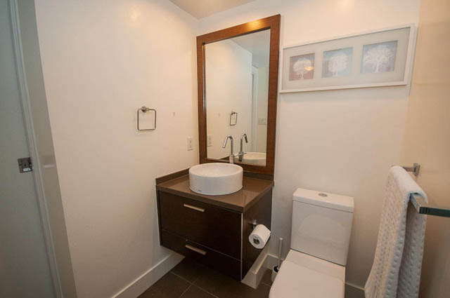 Bright bathroom with modern vanity, framed art, and toilet. - 1003 - 535 Smithe St, Vancouver Downtown