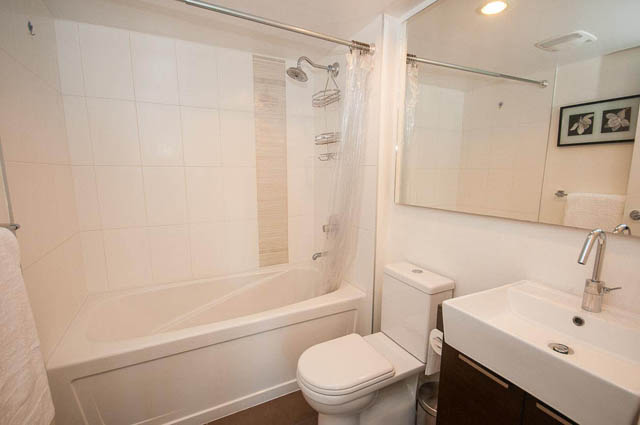 Furnished bathroom with white tiles, modern sink, and shower. - 1003 - 535 Smithe St, Vancouver Downtown