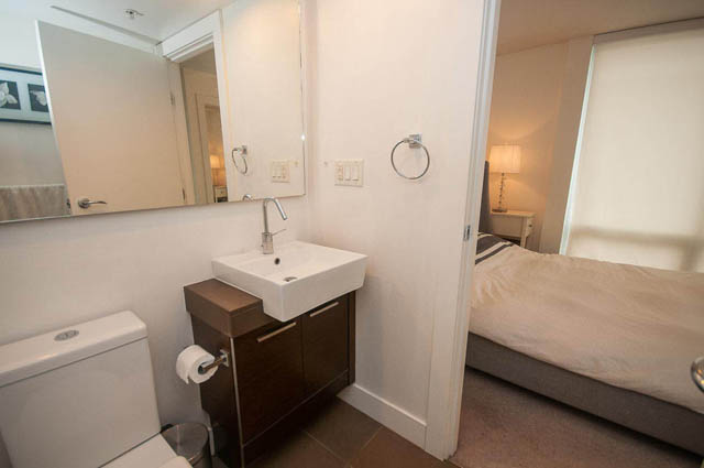 Furnished bathroom with modern sink, large mirror, and neutral tones. - 1003 - 535 Smithe St, Vancouver Downtown