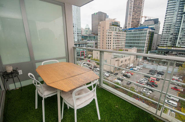 Bright balcony with city view, furnished table and chairs, modern cityscape backdrop. - 1003 - 535 Smithe St, Vancouver Downtown