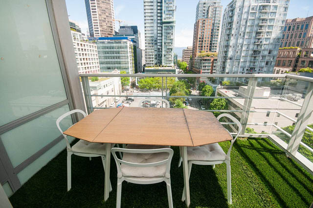 Furnished balcony with city view and greenery, modern furnishings. - 1003 - 535 Smithe St, Vancouver Downtown